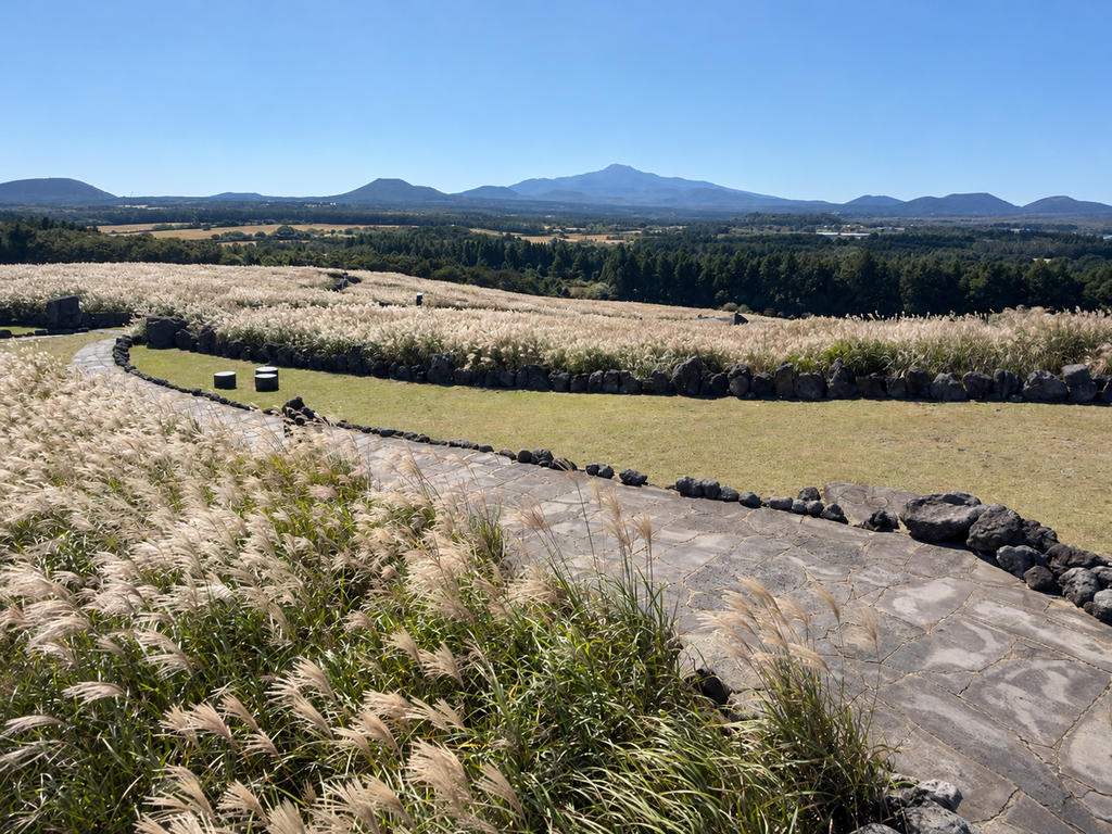 Stone path through silver grass with a distant mountain ridge